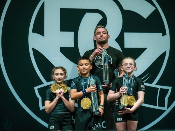 Labyrinth BJJ coach and kids celebrating on the Battleground podium
